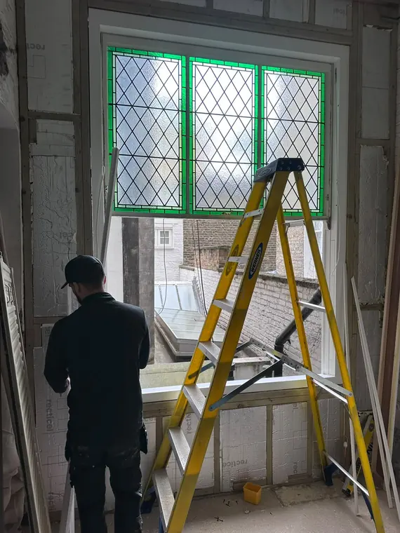 Decorative glass being fitted into painted window joinery